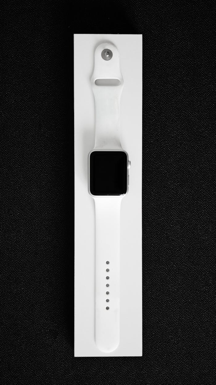 White smartwatch showcased in a minimalist style on black background, emphasizing modern design.